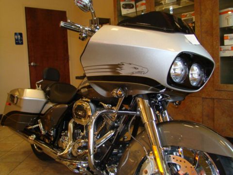 2009 Harley-Davidson FLH - A silver and black motorcycle with a large fairing and dual headlights is displayed indoors.