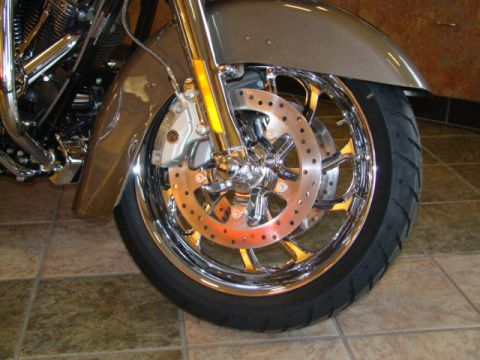2009 Harley-Davidson FLH - Close-up of a motorcycle's front wheel assembly, showing chrome details and a gold-colored fender.