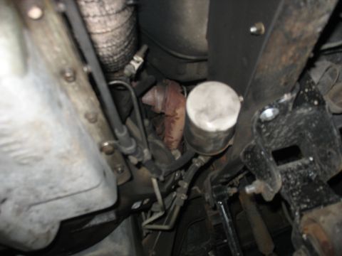 1995 Ford C-350 (Centurion Conversions) - Close-up of vehicle transmission and oil filter assembly, showing various mechanical parts.