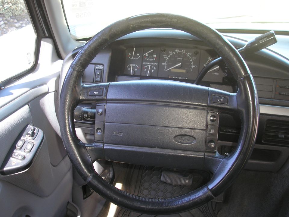 Black steering wheel and dashboard of a 1995 Ford Bronco