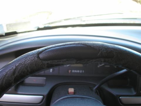 1995 Ford Bronco - Interior view of a 1995 Ford Bronco, focusing on the worn steering wheel and gear selector.