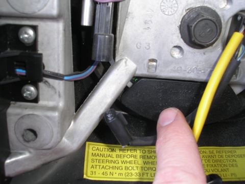 1995 Ford Bronco - Detail of steering wheel assembly, showing wiring and a warning label about torque specifications.