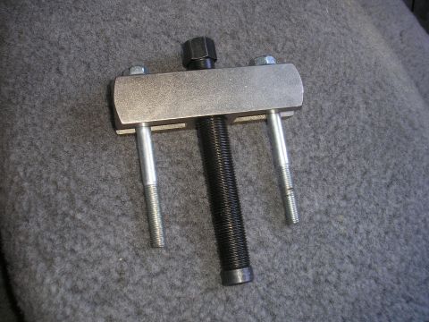 1995 Ford Bronco - A steering wheel puller tool is shown against a gray, textured background.