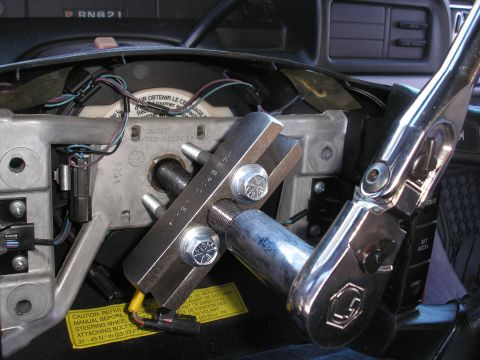 1995 Ford Bronco - A steering wheel puller tool is attached to the steering column, indicating a repair or replacement is in progress.