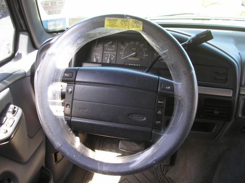 1995 Ford Bronco - Interior view of a 1995 Ford Bronco, a steering wheel covered in protective plastic.