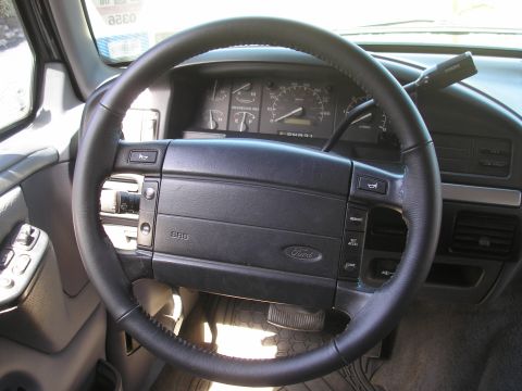 1995 Ford Bronco - The dashboard and steering wheel of a Ford truck, with the Ford logo visible on the steering wheel.