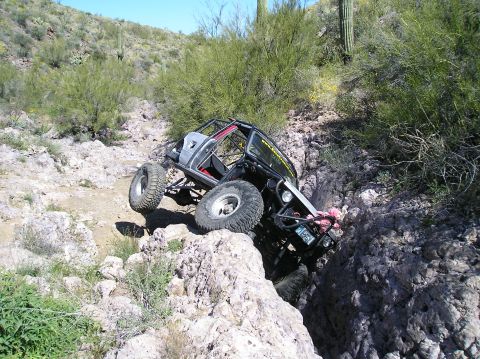 1986 Toyota Hilux - This heavily modified off-road vehicle appears to be from the early 1980s, not a 1986 Toyota Hilux, as it navigates a challenging rocky ter…