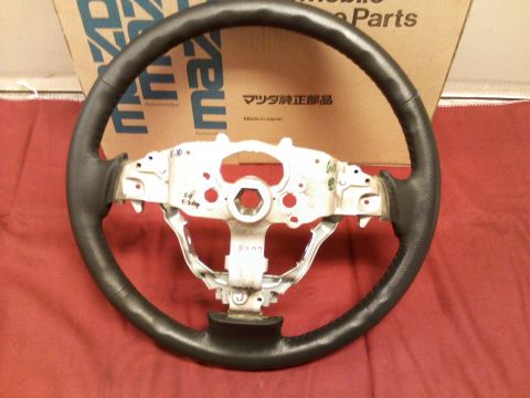 2007 Mazda CX-7 - A steering wheel is shown with a cardboard box in the background that has 'Mazda' printed on it.