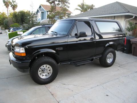 1986 Ford Bronco - This black SUV, likely a 1992-1996 Ford Bronco, is shown from a 3/4 front angle.