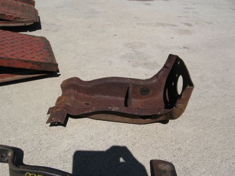 1986 Ford Bronco - A heavily rusted metal part is shown on a concrete surface, with other metal pieces in the background.
