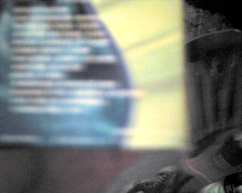 1990 Ford Taurus - The image shows blurry text on a blue background, with the Supermotors logo visible at the bottom right.