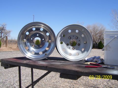 1993 Ford Bronco - Two aluminum wheels are placed on a table outside, ready for work.
