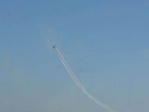 1978 Ford Bronco - An airplane leaves a smoke trail while performing aerobatics in a clear blue sky.