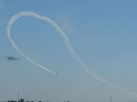 1978 Ford Bronco - An airplane creates a heart-shaped smoke trail against a clear blue sky, with a website logo in the corner.