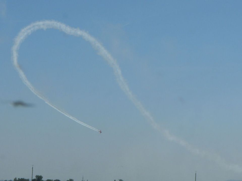 Plane drawing a heart in the sky with smoke. Supermotors.net logo visible