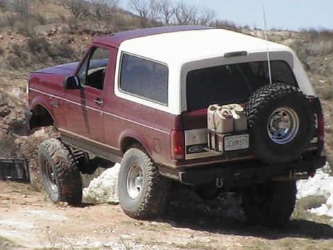 1992 Ford Bronco - This 1992 Ford Bronco is shown navigating rough terrain with a spare tire and two gas cans mounted on the rear.