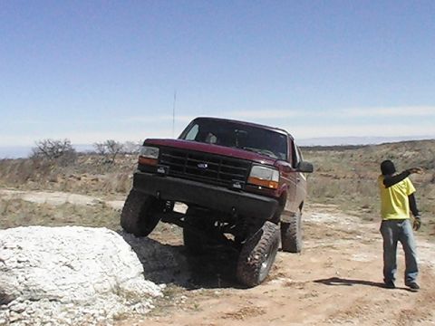 1992 Ford Bronco - 1992 Ford Bronco navigating an obstacle on an off-road course.