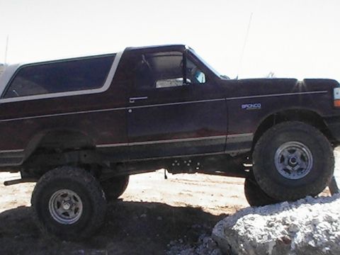 1992 Ford Bronco - This 1992 Ford Bronco is shown in a side profile, navigating rocky terrain.