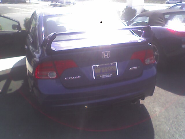 Rear view of blue Honda Civic with spoiler and custom license plate frame
