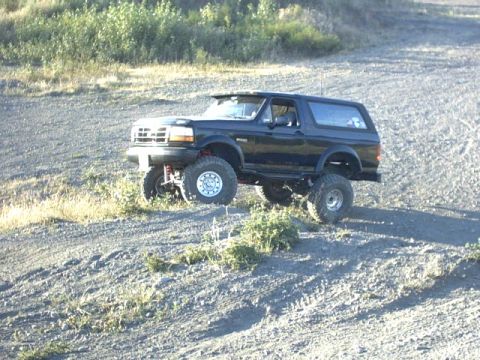 1995 Ford Bronco - This lifted 1995 Ford Bronco navigates a rough, outdoor terrain.