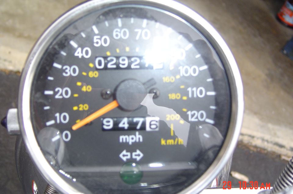 Motorcycle speedometer reading 9476 miles with trip showing 0292