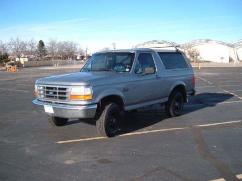 1994 Ford Bronco - This 1994 Ford Bronco is parked in an asphalt lot under a clear blue sky.