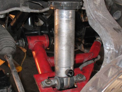 2001 Pontiac Trans Am - Close-up view of automotive suspension components, including a red control arm and a silver adjustable coilover shock.