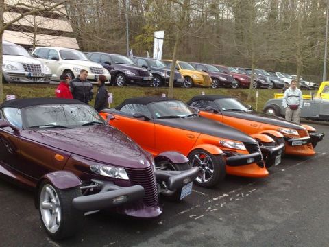 1991 Ford Crown Victoria - A line of Chrysler Prowlers, including a purple and an orange model, are parked together at an outdoor event.