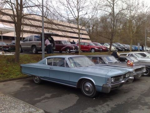 1991 Ford Crown Victoria - A light blue 1967 Chrysler Imperial coupe is parked in a lot with several other vehicles visible.