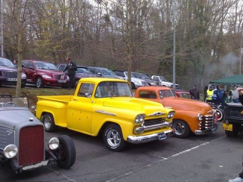 1991 Ford Crown Victoria - A bright yellow 1959 pickup truck is parked at a car show alongside other vintage vehicles.
