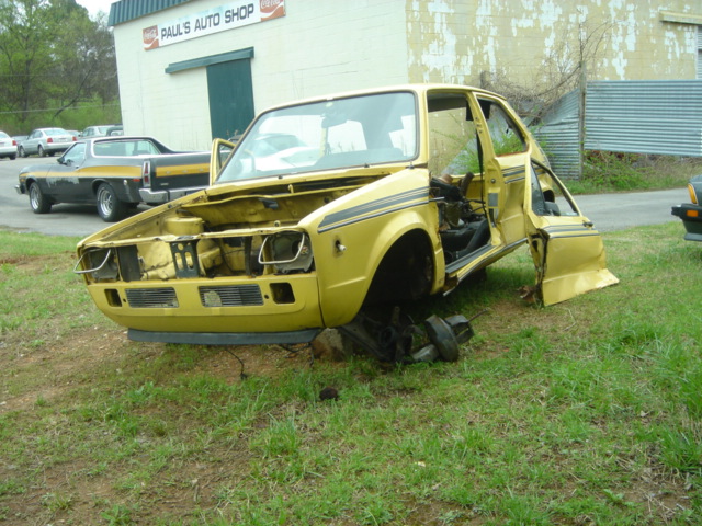 Wrecked yellow hatchback front end near Paul's Auto Shop