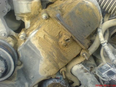 1992 Ford Crown Victoria - Close-up view of a heavily soiled engine timing cover, obscuring any identifying marks or details.