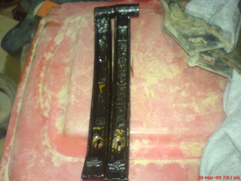 1992 Ford Crown Victoria - Two greasy timing guides are shown on a red surface, possibly for engine maintenance.