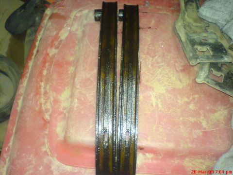 1992 Ford Crown Victoria - Timing chain guides, likely from an engine, are shown on a red surface.