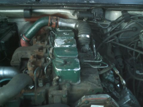 1989 Ford Bronco - Close-up view of a diesel engine's intake and exhaust system, showing various hoses and pipes.