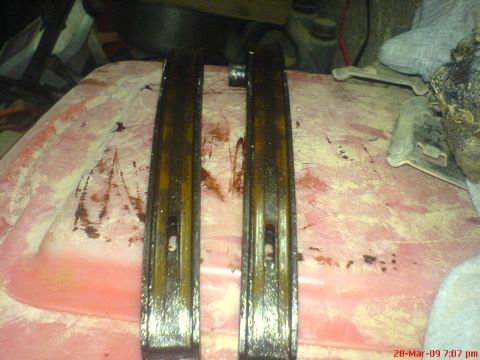 1992 Ford Crown Victoria - Close-up of two used timing chain guides, likely from an engine rebuild project.