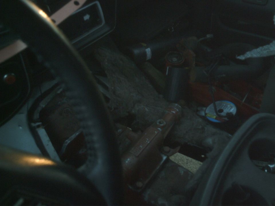Interior view of a cluttered vehicle with tools and a CD