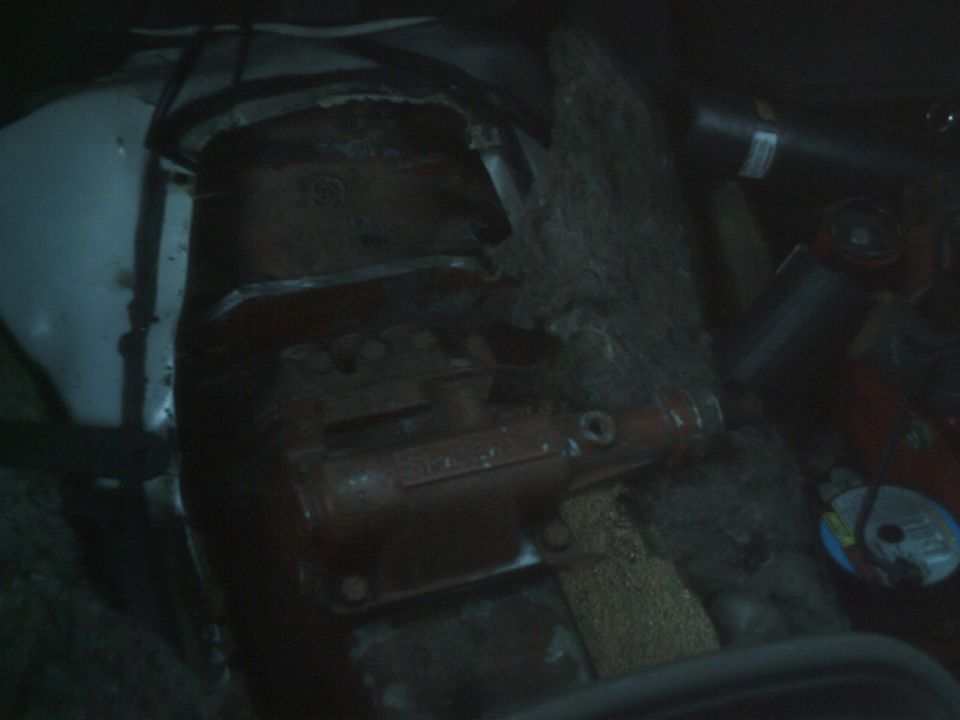 Red transmission component with bolts and housing visible