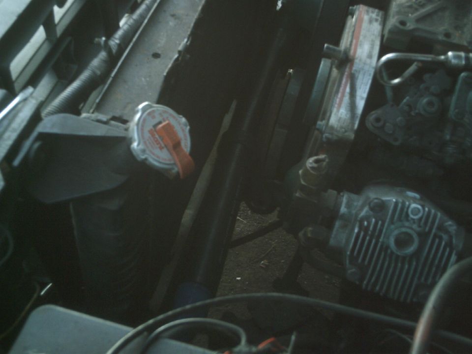 Close-up of an engine bay showing a radiator cap and some engine components