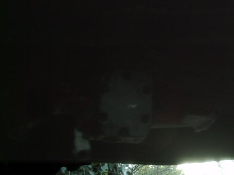 1989 Ford Bronco - The underside of a vehicle is visible, with a component multiple circular indentations.