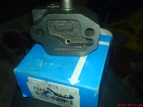 1992 Ford Crown Victoria - A timing chain tensioner part is shown resting on its blue packaging box, which has the part number F6AZ-6L266-CA printed on it.