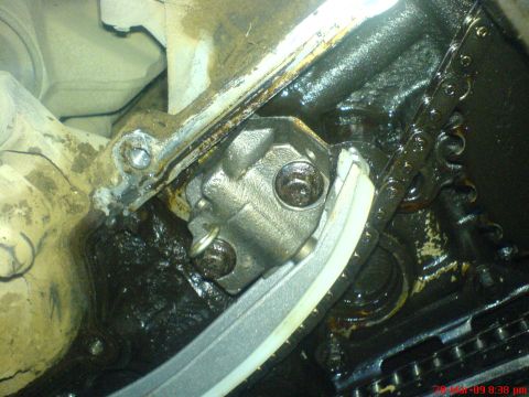 1992 Ford Crown Victoria - Close-up view of an engine's timing chain and tensioner mechanism.