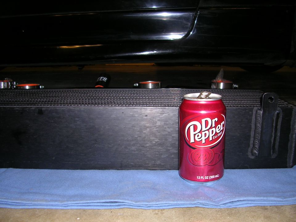 Black car undercarriage with a large black intercooler and a red Dr Pepper can