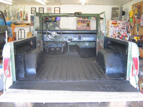1992 Ford Mustang - Interior and bed of a green Ford Bronco, showing the dashboard, steering wheel, and the truck bed with spray-on liner.