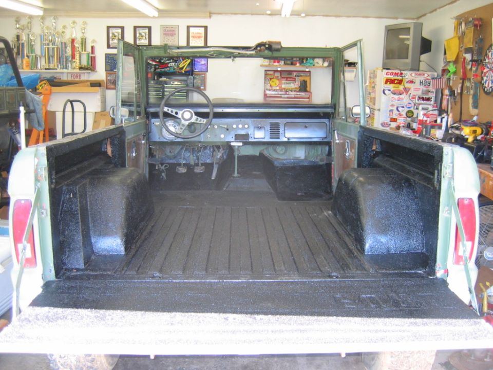 Green Ford Bronco interior and bed, viewed from rear