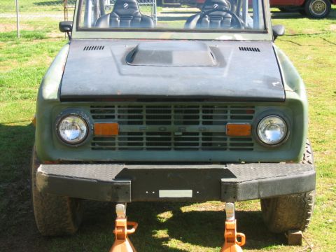 1992 Ford Mustang - A vintage Ford Bronco sits on orange jack stands, its front grille and bumper clearly visible.