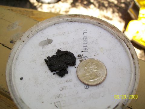 1973 Mercury Cougar - Oil sludge sample shown with a quarter for size comparison, indicating potential engine issues.