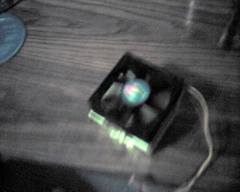1990 Ford Taurus - A computer fan with colorful LED lights is shown on a wooden surface, with a SuperMotors watermark at the bottom right.