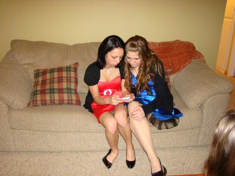 1989 Ford Bronco - Two young women in formal dresses are seated on a couch, engrossed in a mobile phone.