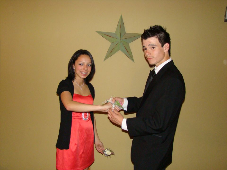 Teenage couple dressed up for prom, boy in tuxedo, girl in red dress